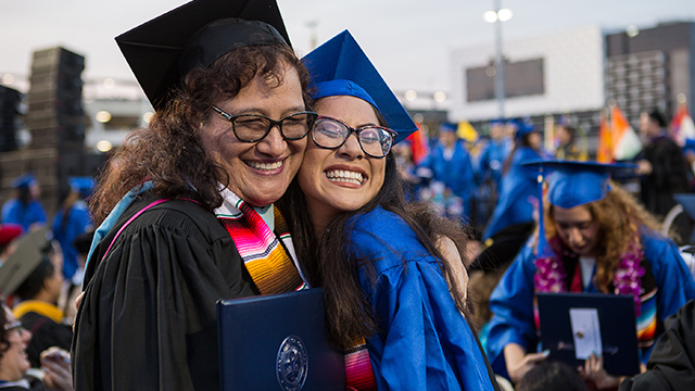 Student and counselor embracing at graduation